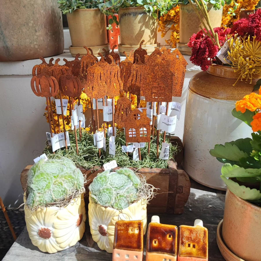 Brautstrauß mit Rosen, Nelken, Eukalyptusblättern und weiteren Blüten in Pastelltönen vor Holztür